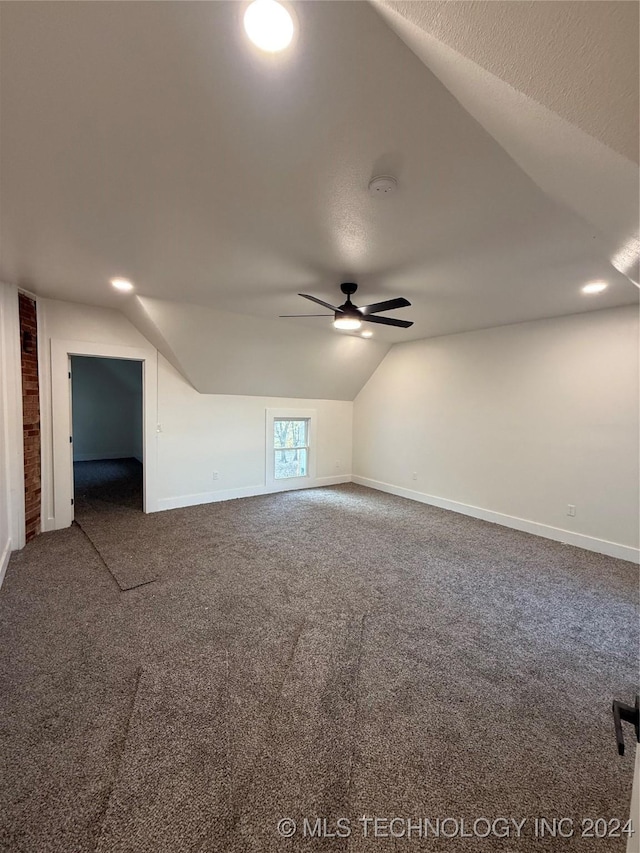 additional living space featuring a textured ceiling, carpet floors, ceiling fan, and lofted ceiling