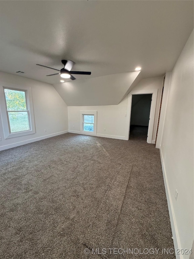 bonus room with dark colored carpet, ceiling fan, and lofted ceiling