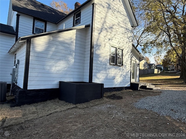 view of side of home with central AC unit