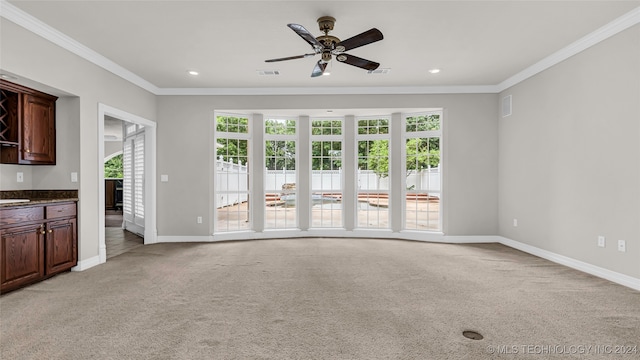 unfurnished living room with ceiling fan, crown molding, and light carpet