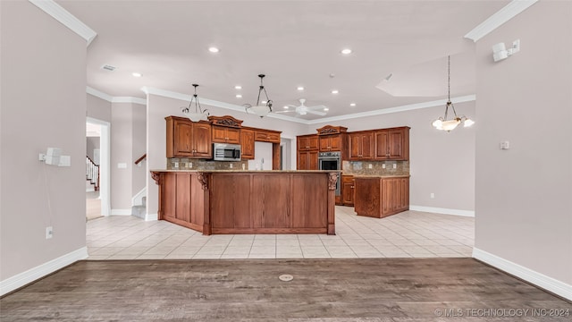 kitchen featuring backsplash, ceiling fan with notable chandelier, hanging light fixtures, light tile patterned floors, and ornamental molding