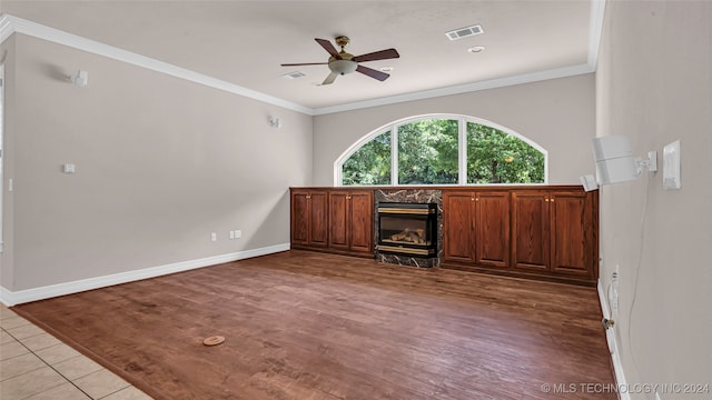 unfurnished living room featuring light hardwood / wood-style floors, ceiling fan, ornamental molding, and a premium fireplace