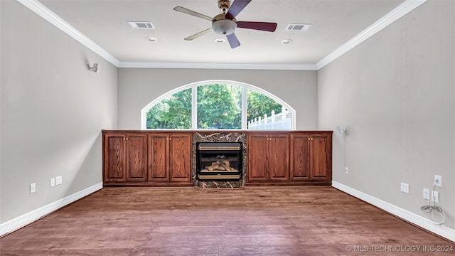 unfurnished living room with ceiling fan, wood-type flooring, crown molding, and a premium fireplace