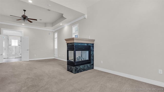 unfurnished living room with a multi sided fireplace, plenty of natural light, and carpet floors