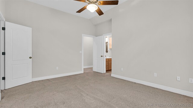 unfurnished bedroom featuring light carpet, ensuite bathroom, vaulted ceiling, and ceiling fan