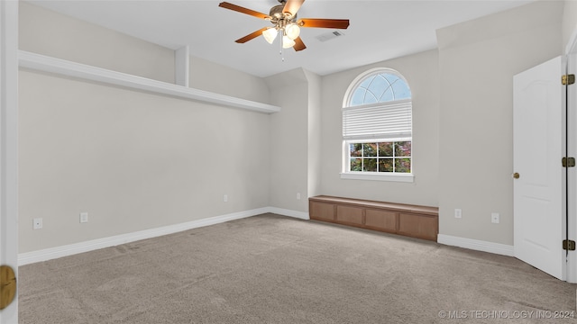 empty room featuring ceiling fan and light colored carpet