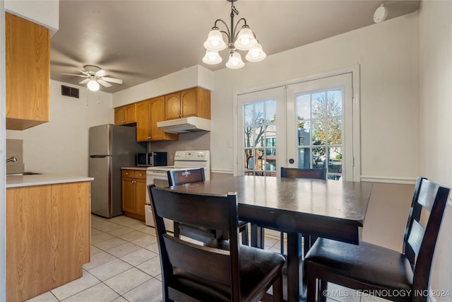 tiled dining space featuring french doors, ceiling fan with notable chandelier, and sink