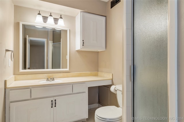 bathroom featuring toilet, vanity, tile patterned floors, and walk in shower