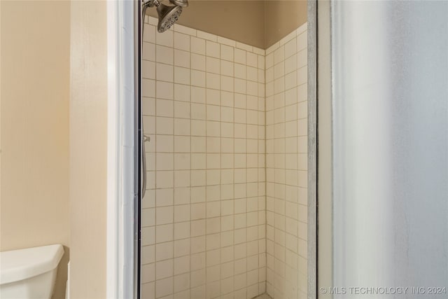 bathroom featuring toilet and a shower with door