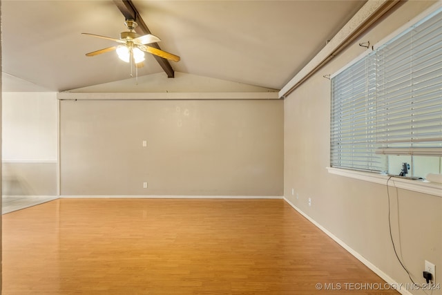 empty room featuring hardwood / wood-style floors, lofted ceiling with beams, and ceiling fan