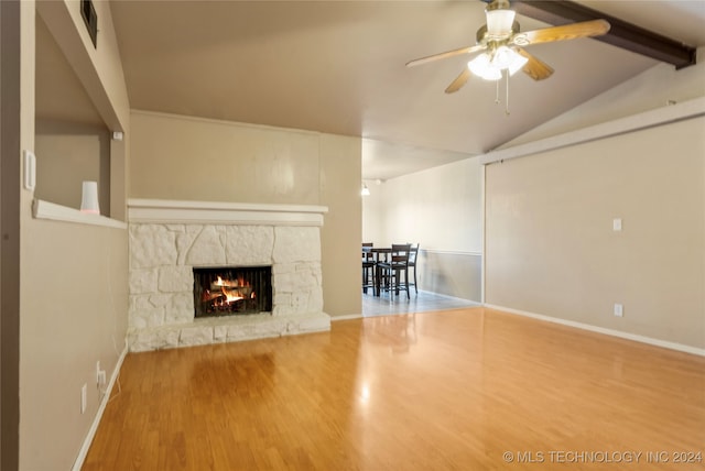 unfurnished living room with a fireplace, hardwood / wood-style floors, lofted ceiling with beams, and ceiling fan