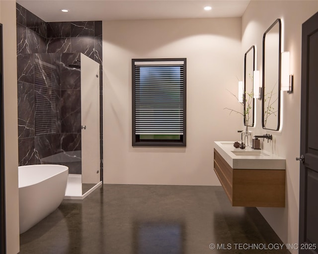 bathroom with a washtub, vanity, and concrete floors