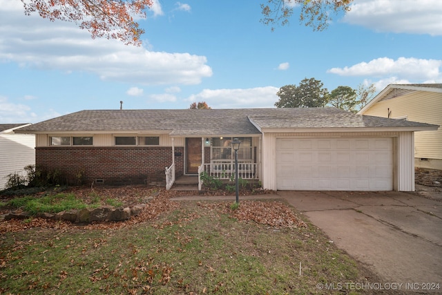 ranch-style house with a porch, a garage, and a front lawn