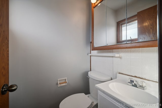 bathroom with backsplash, vanity, toilet, and tile walls