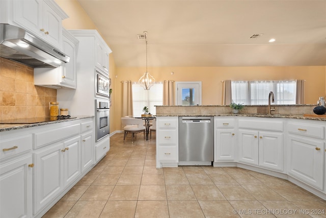 kitchen featuring white cabinets, stainless steel appliances, light stone counters, and plenty of natural light