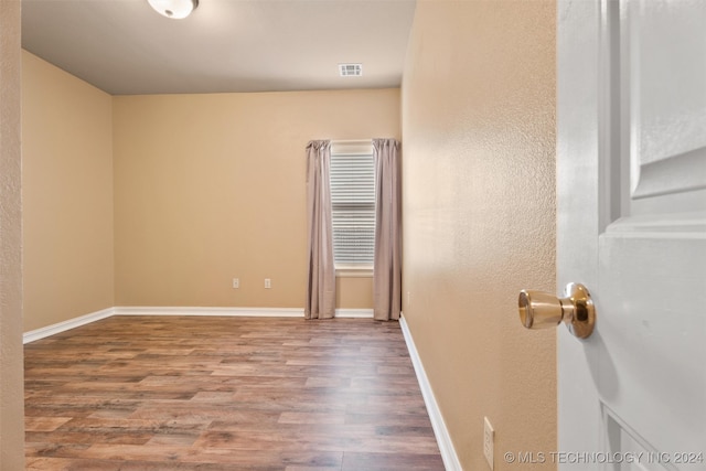 unfurnished room with wood-type flooring