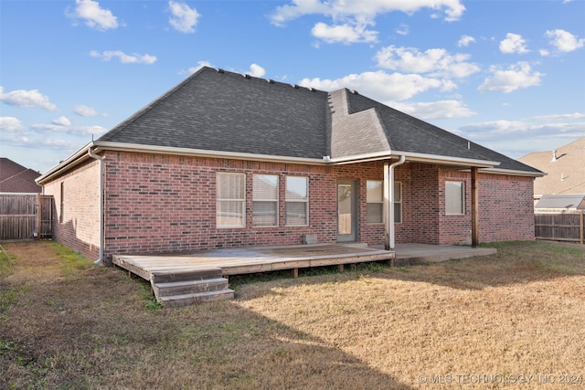 back of property featuring a wooden deck, a patio area, and a yard