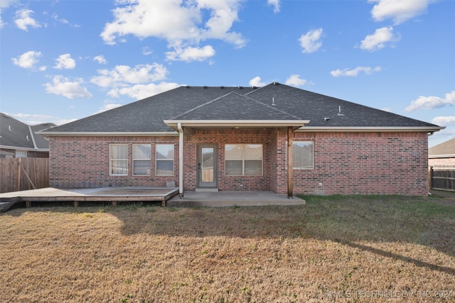 back of property featuring a yard, a deck, and a patio area