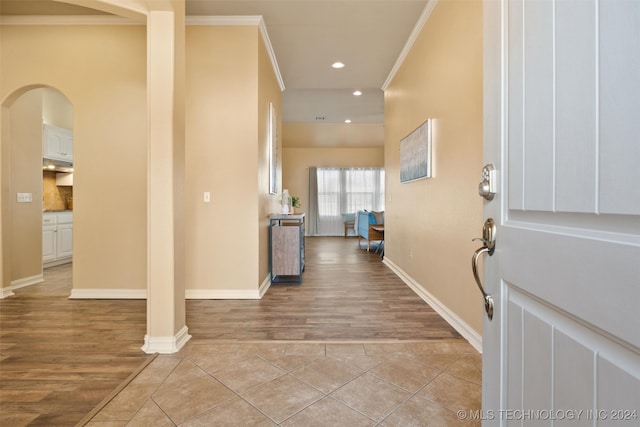 foyer entrance with light hardwood / wood-style floors and ornamental molding