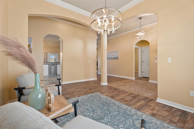 interior space with hardwood / wood-style flooring, ornamental molding, and an inviting chandelier