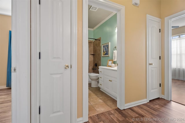 bathroom with vanity, toilet, wood-type flooring, and ornamental molding