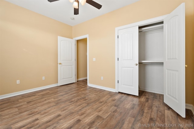 unfurnished bedroom featuring dark hardwood / wood-style floors, ceiling fan, and a closet