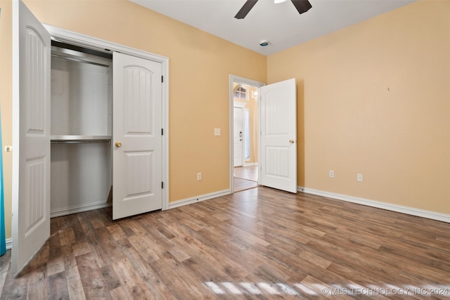 unfurnished bedroom featuring hardwood / wood-style floors, ceiling fan, and a closet