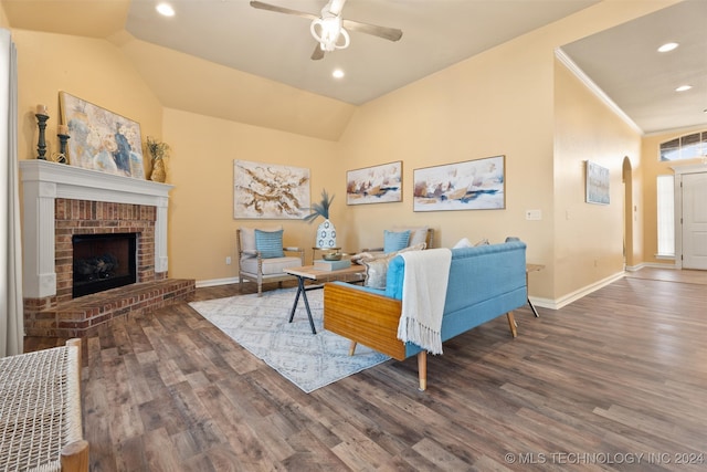 living room with a fireplace, dark hardwood / wood-style flooring, vaulted ceiling, and ceiling fan