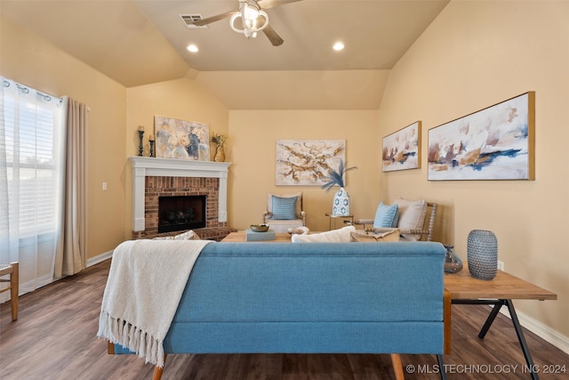 living room with hardwood / wood-style flooring, ceiling fan, lofted ceiling, and a brick fireplace