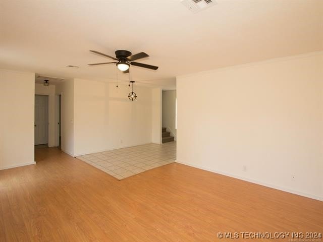 empty room with light hardwood / wood-style floors and ceiling fan