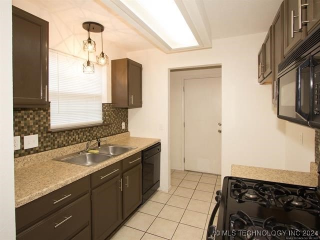 kitchen featuring decorative backsplash, dark brown cabinetry, sink, black appliances, and decorative light fixtures