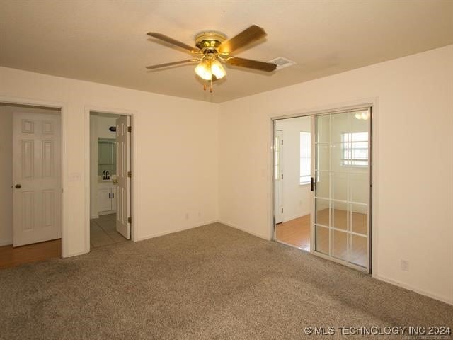 unfurnished bedroom featuring carpet flooring, connected bathroom, and ceiling fan