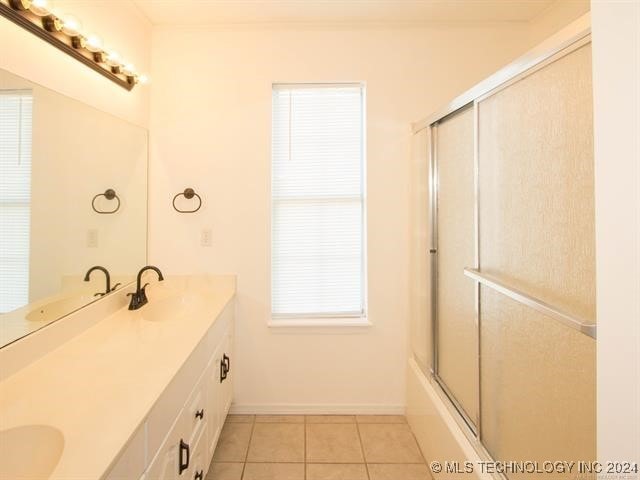 1132 W Florence Ct, Broken Arrow, OK 74011 - full bathroom featuring double vanity, tile patterned flooring, enclosed tub / shower combo, and baseboards