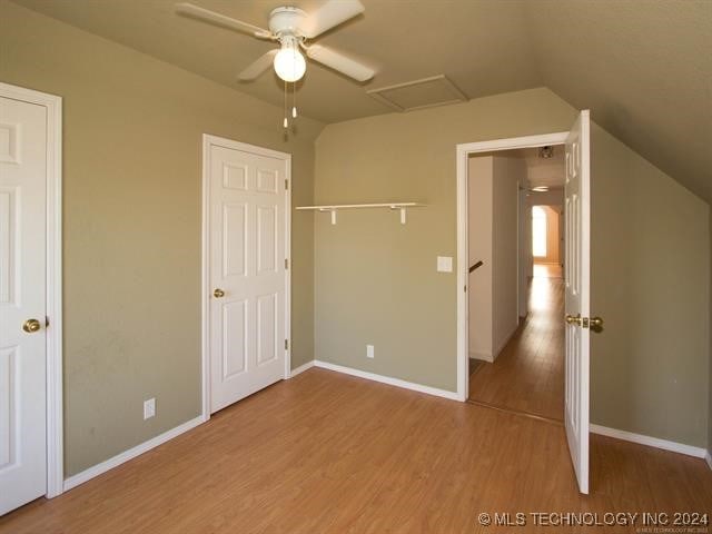 unfurnished bedroom featuring hardwood / wood-style flooring, ceiling fan, and lofted ceiling