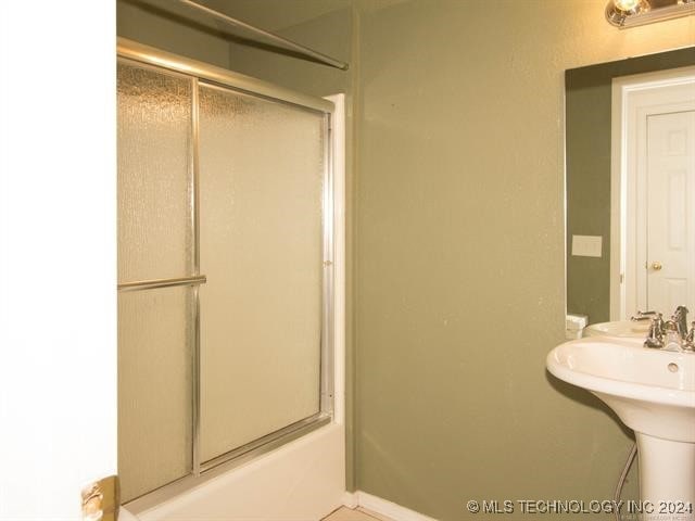 bathroom with combined bath / shower with glass door