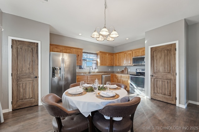 dining room with an inviting chandelier, dark hardwood / wood-style flooring, and sink