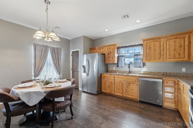 kitchen with pendant lighting, appliances with stainless steel finishes, sink, and a wealth of natural light