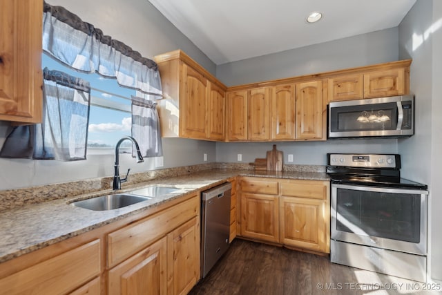 kitchen featuring dark hardwood / wood-style flooring, sink, stainless steel appliances, and light stone countertops