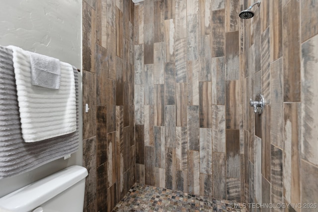 bathroom with tiled shower and toilet