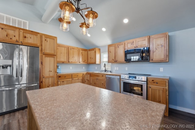 kitchen featuring dark wood-type flooring, stainless steel appliances, light brown cabinetry, and vaulted ceiling with beams