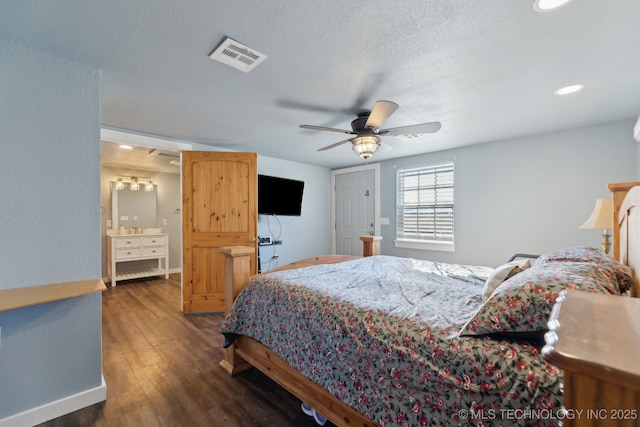 bedroom featuring dark hardwood / wood-style flooring, ceiling fan, and a textured ceiling