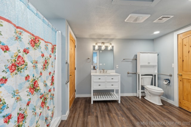 bathroom featuring hardwood / wood-style flooring, vanity, a textured ceiling, curtained shower, and toilet