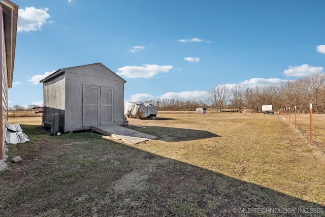 view of yard featuring a rural view and a shed