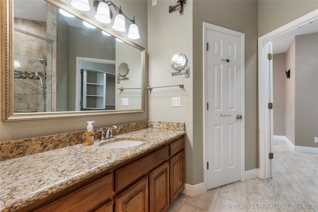 bathroom featuring tile patterned floors, vanity, and tiled shower