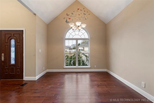 foyer entrance featuring dark hardwood / wood-style flooring, high vaulted ceiling, and an inviting chandelier