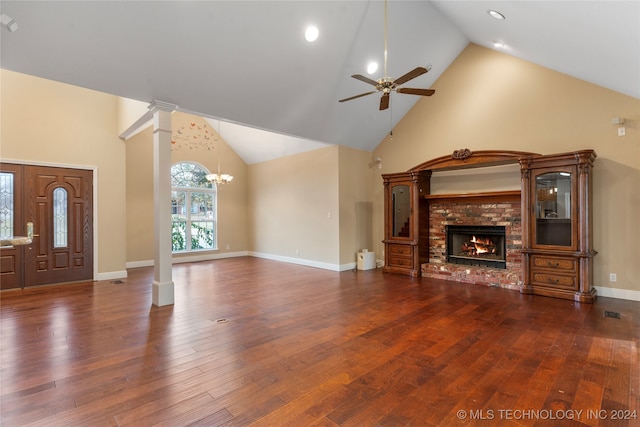 unfurnished living room with ceiling fan with notable chandelier, a fireplace, dark wood-type flooring, and high vaulted ceiling