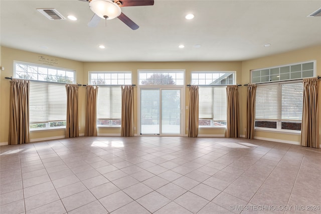 tiled empty room featuring a wealth of natural light and ceiling fan