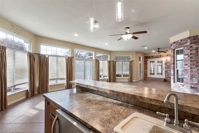 kitchen featuring pendant lighting, light tile patterned floors, sink, and a wealth of natural light