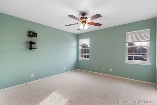 empty room with ceiling fan, a healthy amount of sunlight, and carpet floors