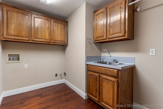 clothes washing area with cabinets, washer hookup, gas dryer hookup, sink, and dark hardwood / wood-style floors